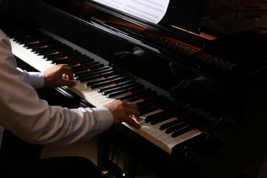 Man playing grand piano, closeup. Talented musician