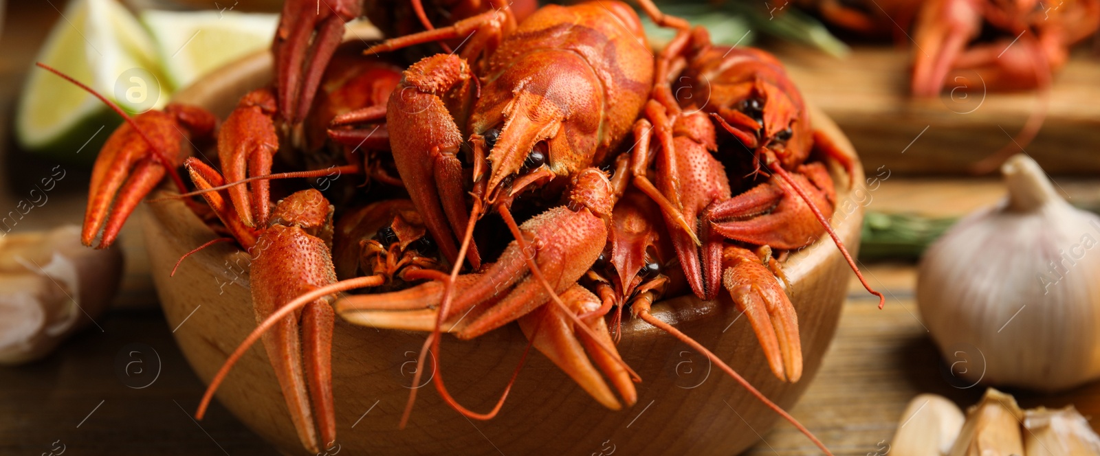 Image of Delicious red boiled crayfishes on table, closeup. Banner design