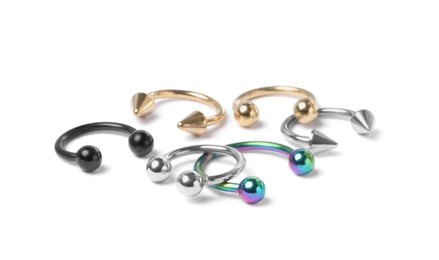 Piercing jewelry. Many different circular barbells on white background