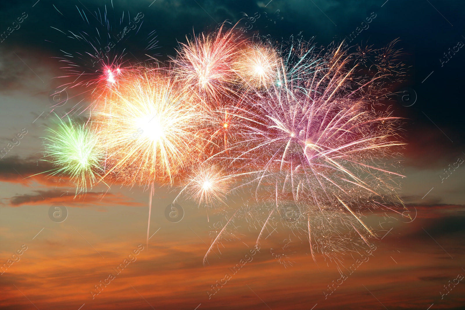 Image of Beautiful bright fireworks lighting up twilight sky outdoors