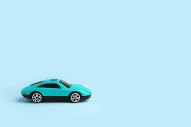 One bright car on light blue background, space for text. Children`s toy