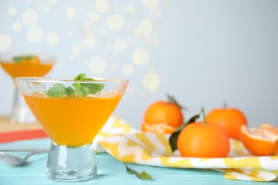 Photo of Delicious tangerine jelly on light blue wooden table