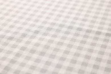 Beige checkered tablecloth as background, closeup view