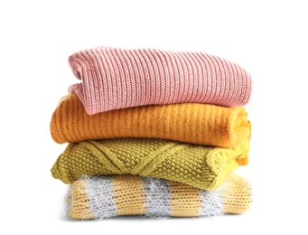 Photo of Stack of warm knitted clothes on white background