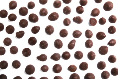 Photo of Delicious dark chocolate chips on white background, flat lay