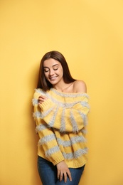 Photo of Beautiful young woman in warm sweater on color background