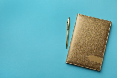 Photo of New stylish planner with leather cover and pen on light blue background, flat lay. Space for text
