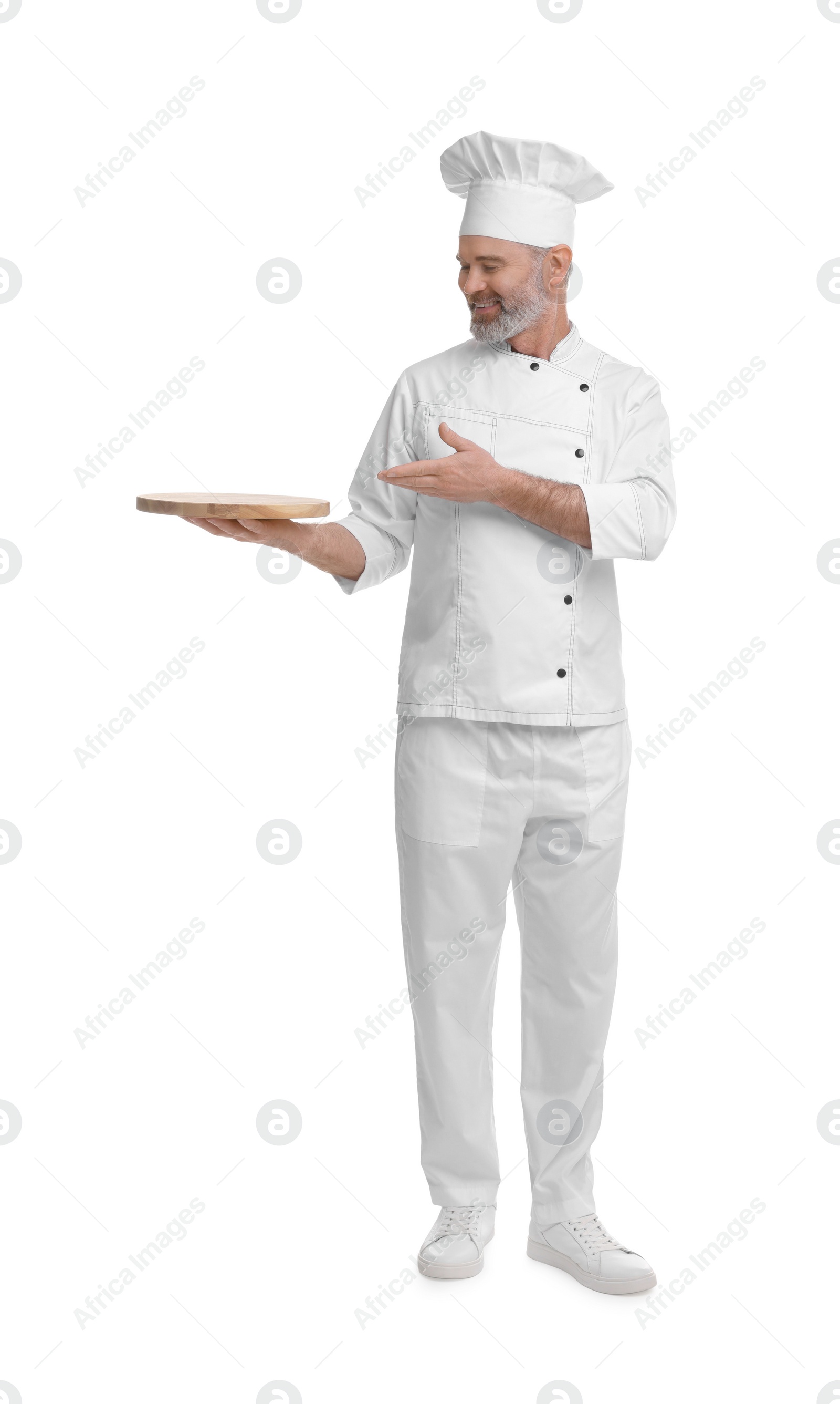 Photo of Happy chef in uniform pointing at wooden board on white background