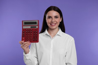 Photo of Smiling accountant with calculator on purple background