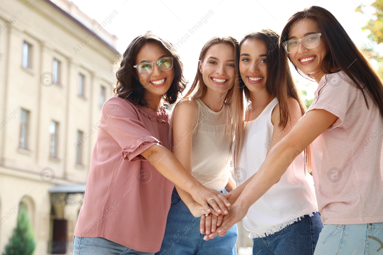 Photo of Happy women putting hands together outdoors. Girl power concept