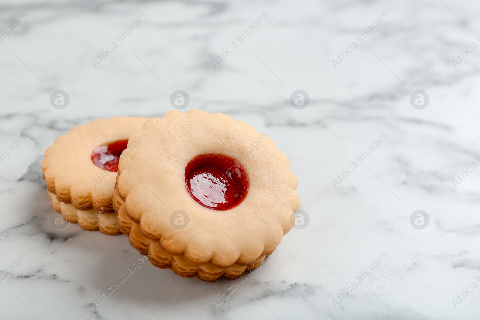 Photo of Traditional Christmas Linzer cookies with sweet jam on marble background