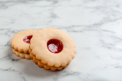 Photo of Traditional Christmas Linzer cookies with sweet jam on marble background