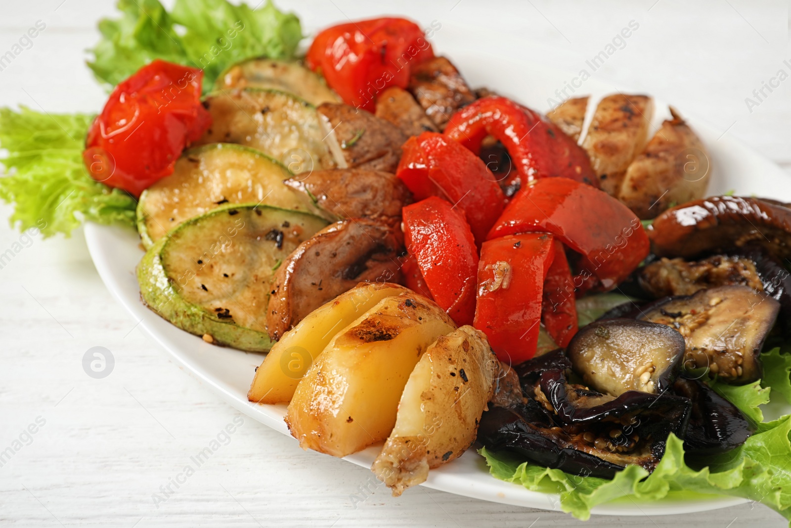 Photo of Plate with tasty grilled vegetables on table, closeup