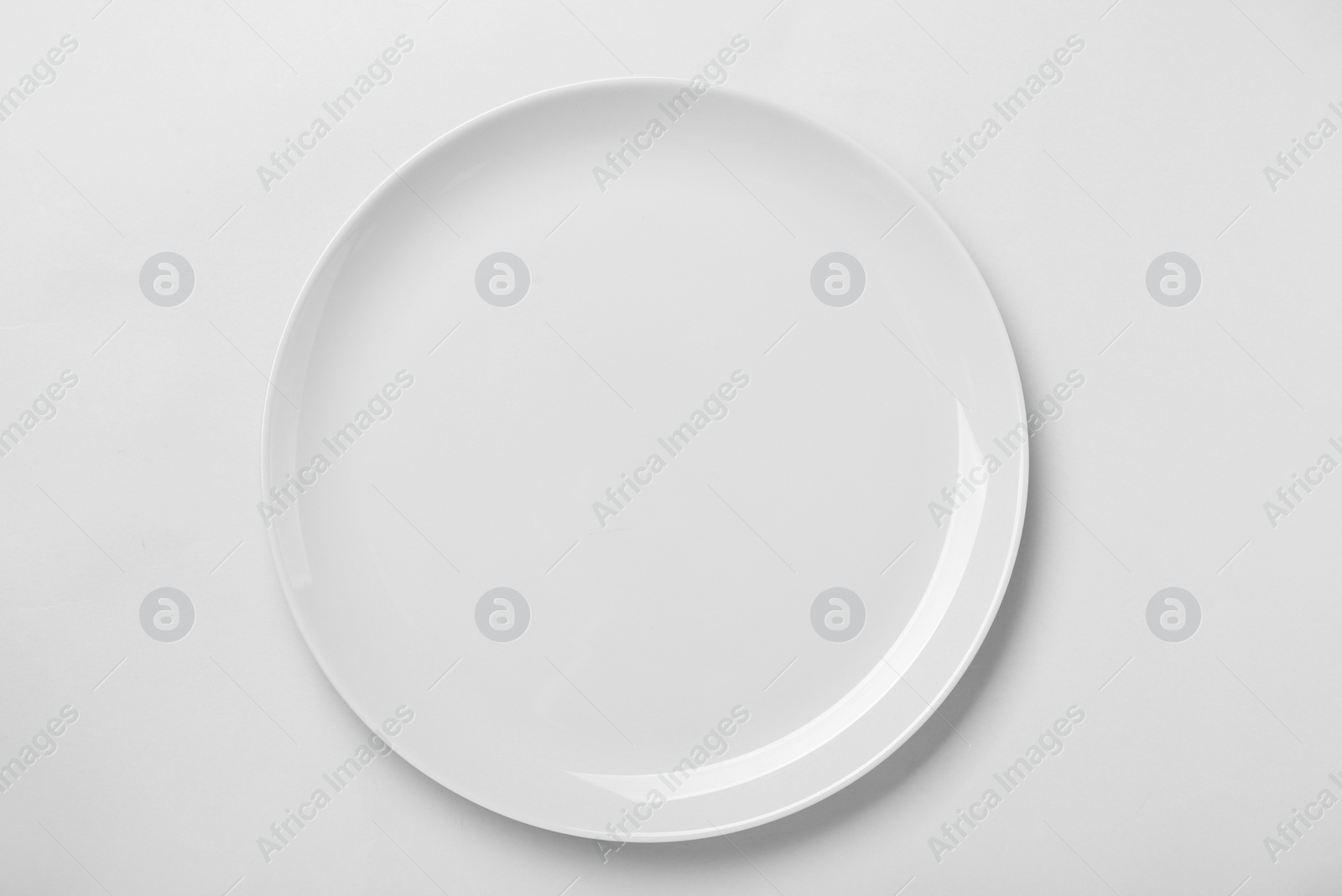 Photo of Empty ceramic plate on white background, top view