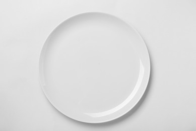 Photo of Empty ceramic plate on white background, top view