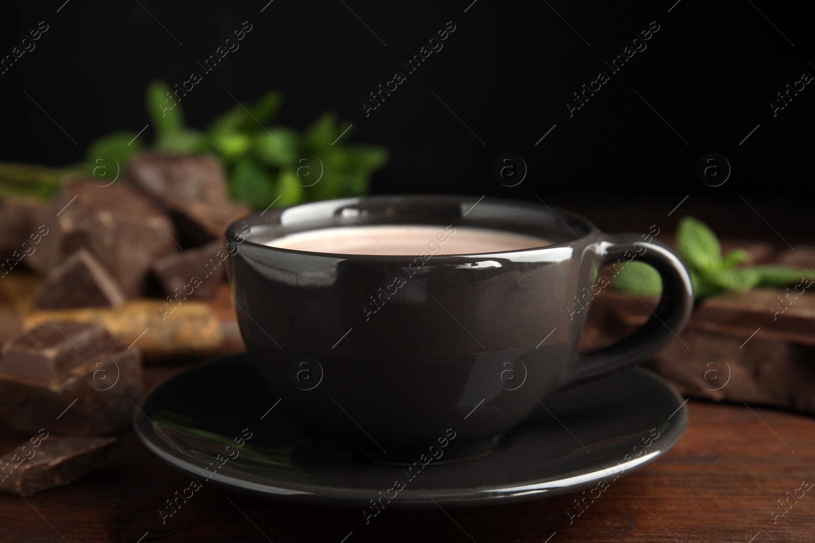 Photo of Cup of delicious hot cocoa on wooden table, closeup