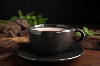 Cup of delicious hot cocoa on wooden table, closeup