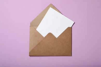 Letter envelope with card on violet background, top view