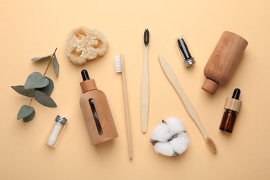 Photo of Flat lay composition with bamboo toothbrushes on pale orange background