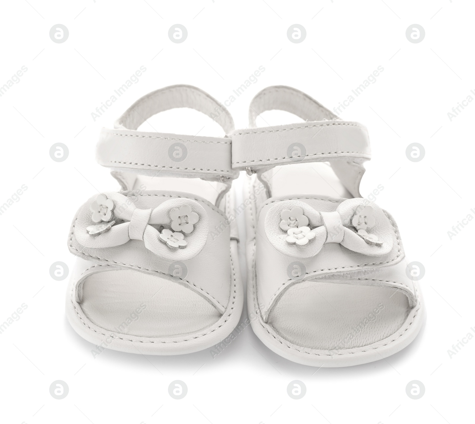 Photo of Pair of cute baby sandals decorated with bows on white background