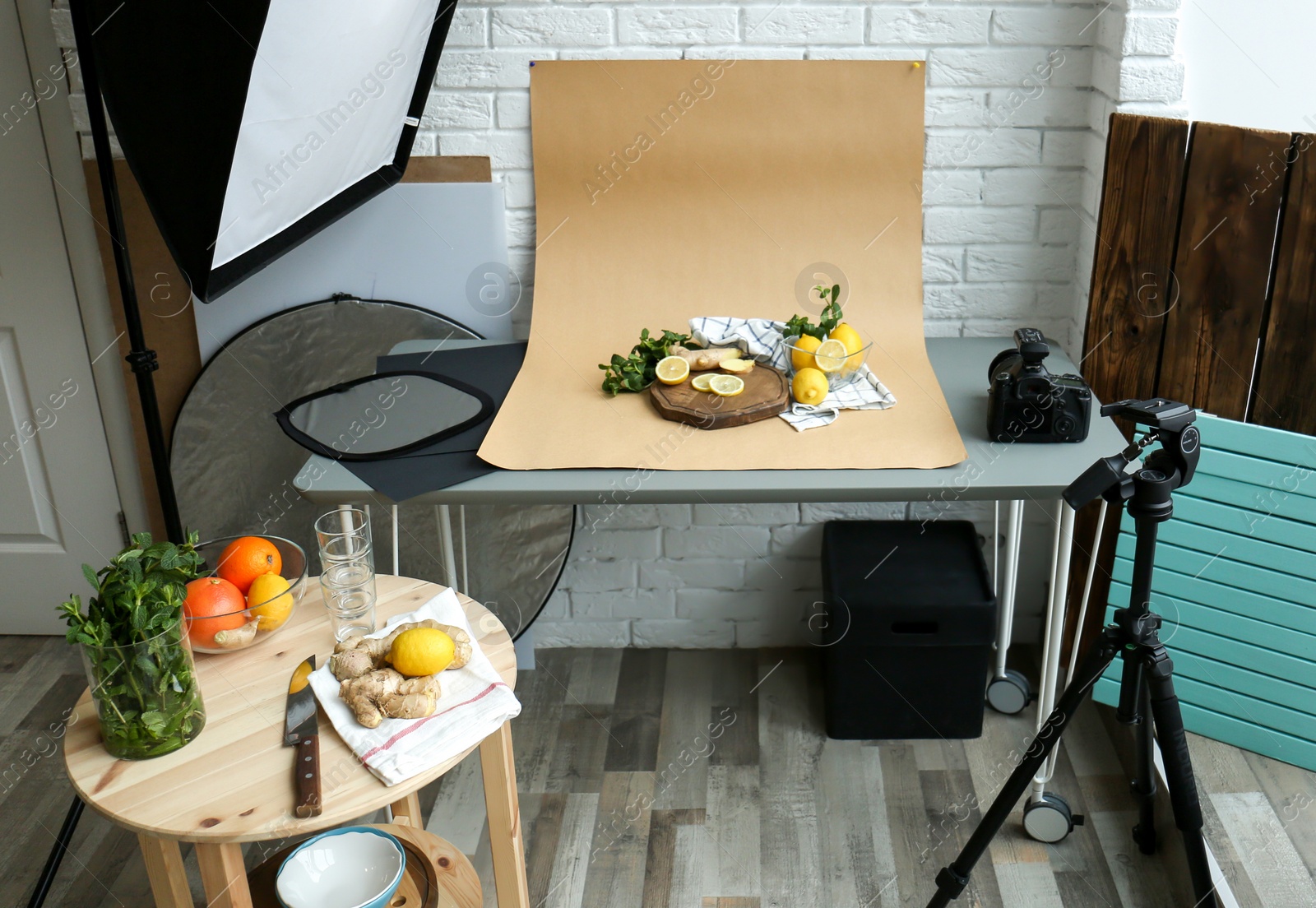 Photo of Cut lemons, mint and ginger on table in professional studio. Food photography