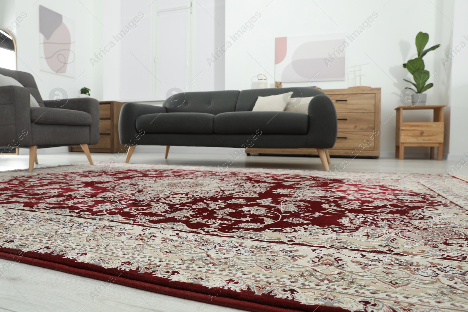 Photo of Cozy room interior with stylish furniture and soft carpet with beautiful pattern