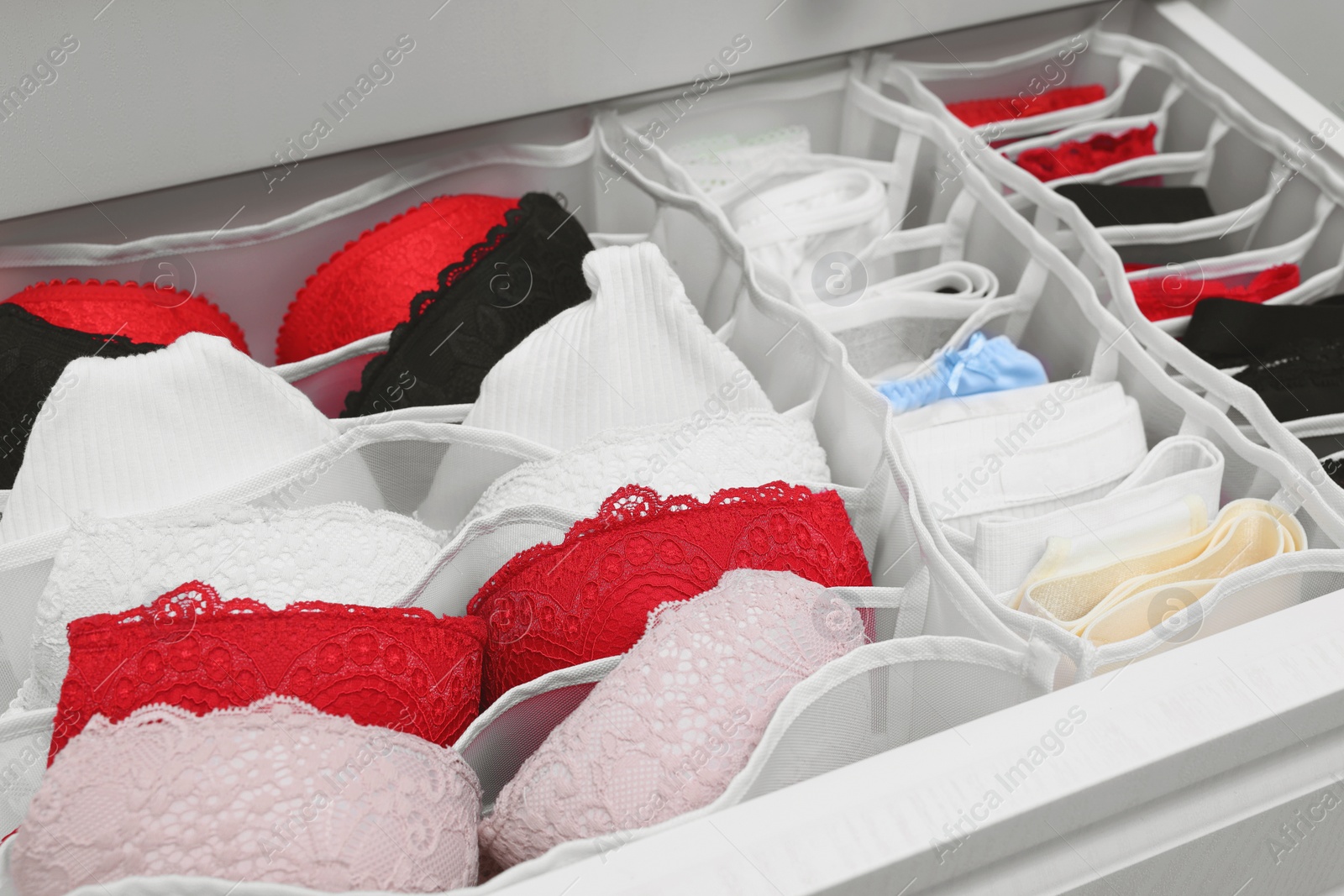 Photo of Organizers with beautiful women's underwear in drawer, closeup