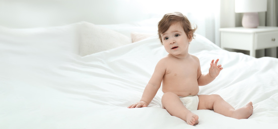 Image of Cute little baby in diaper on bed, space for text. Banner design