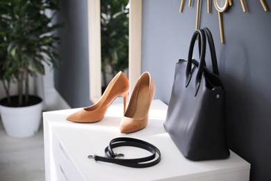 Photo of Stylish women's shoes, belt and bag in modern boutique