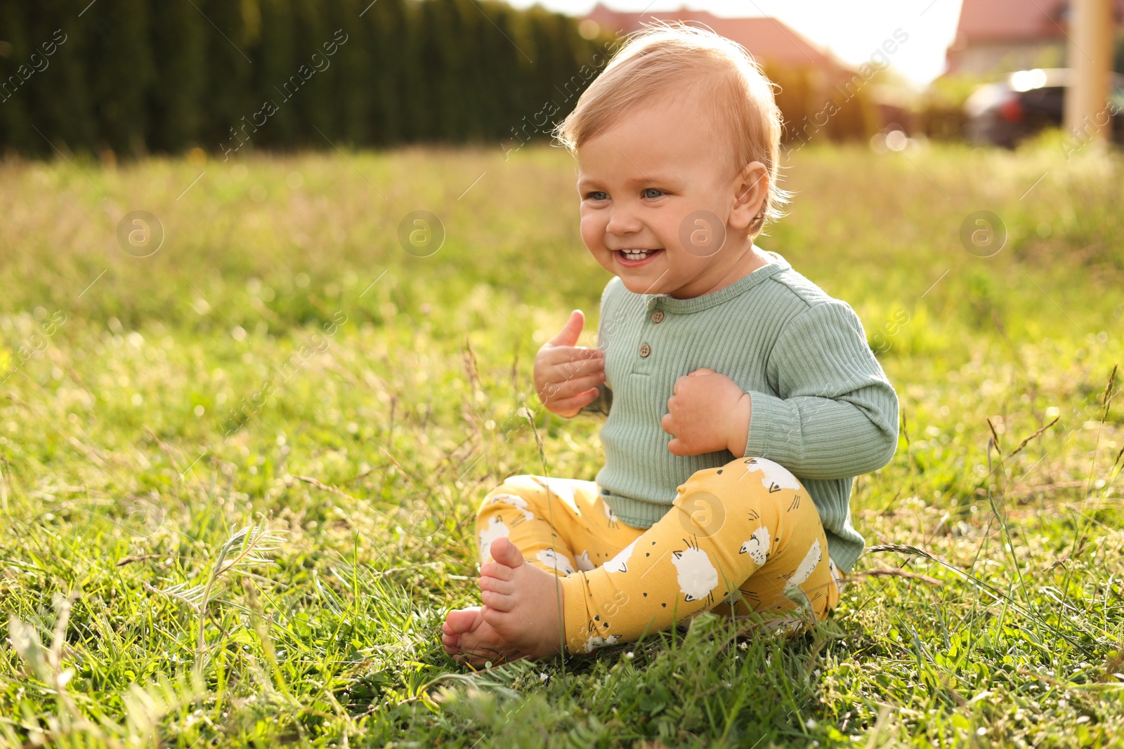 Photo of Cute little child on green grass outdoors