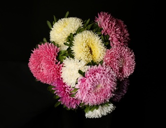 Photo of Bouquet of beautiful asters on black background, top view. Autumn flowers