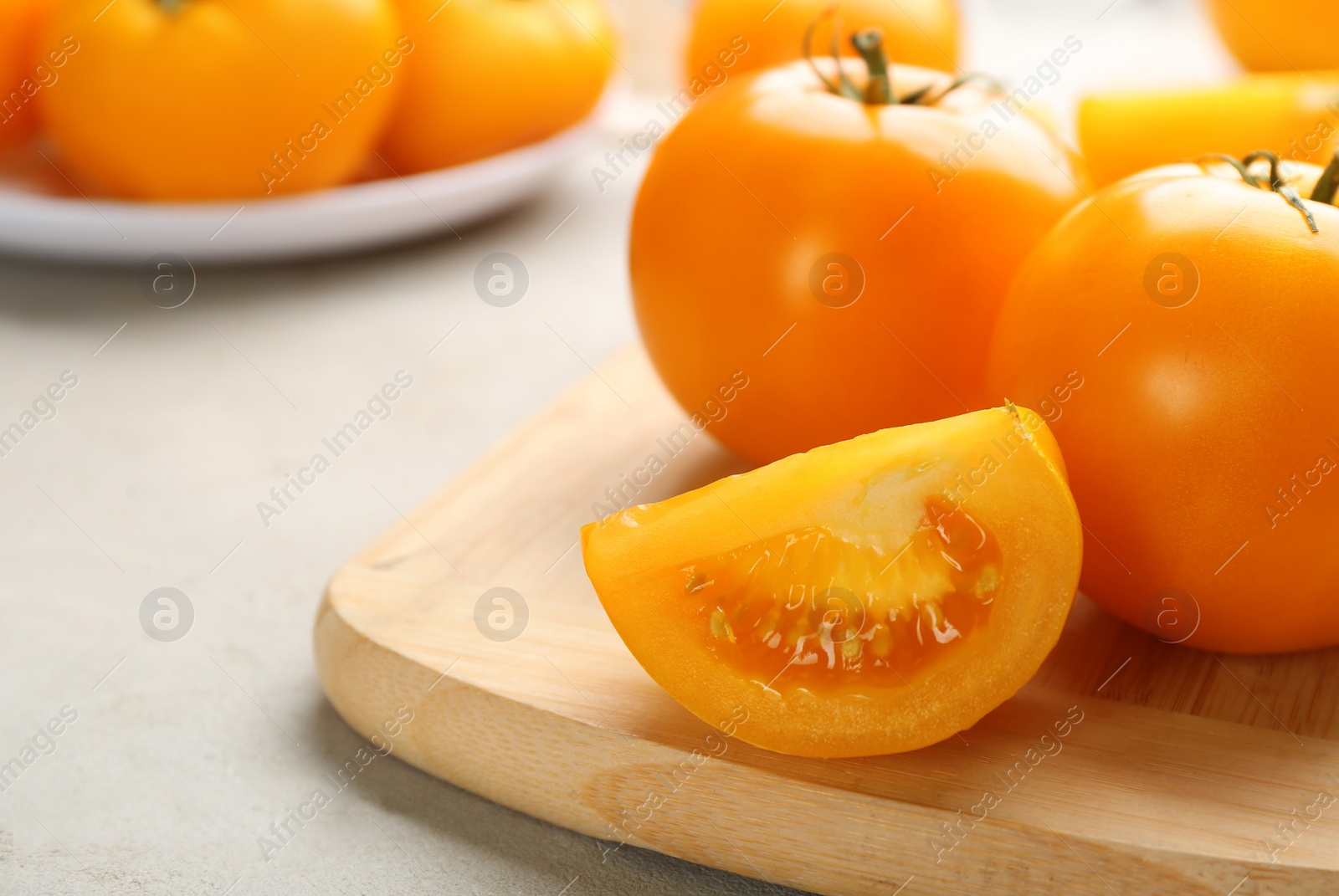 Photo of Ripe yellow tomatoes on grey table, closeup. Space for text