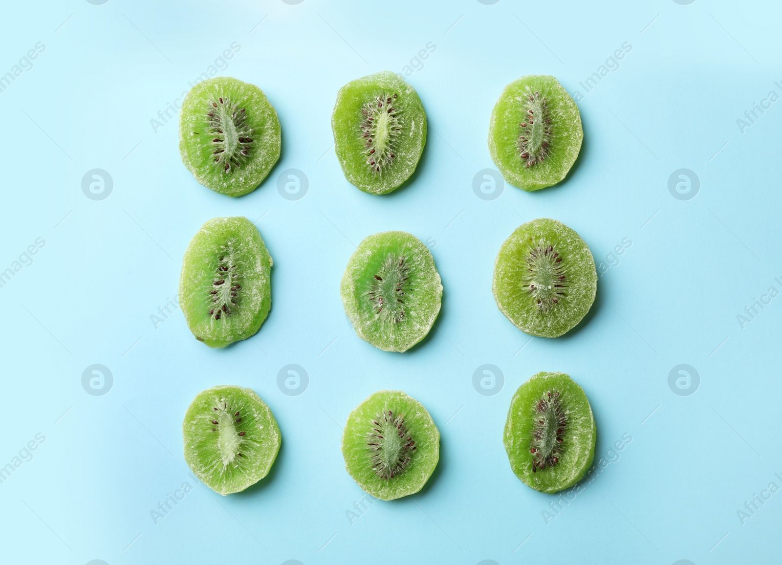Photo of Slices of kiwi on color background, flat lay. Dried fruit as healthy food
