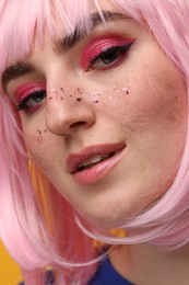 Beautiful woman with bright makeup and glitter freckles, closeup