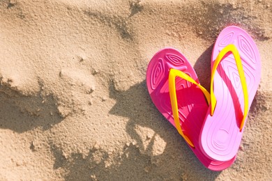 Photo of Stylish flip flops on beach, top view. Space for text