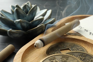 Photo of Acupuncture - alternative medicine. Moxa sticks and antique Chinese coins on table, closeup