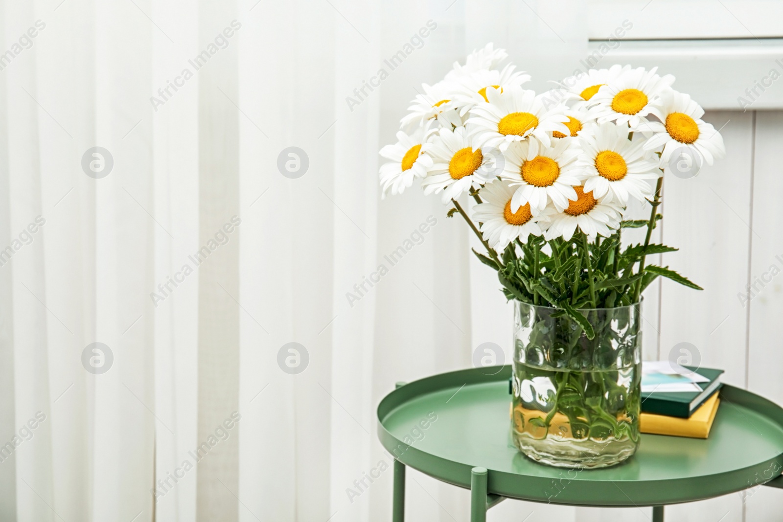 Photo of Vase with beautiful chamomile flowers on table