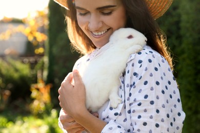 Happy woman with cute rabbit outdoors on sunny day, closeup