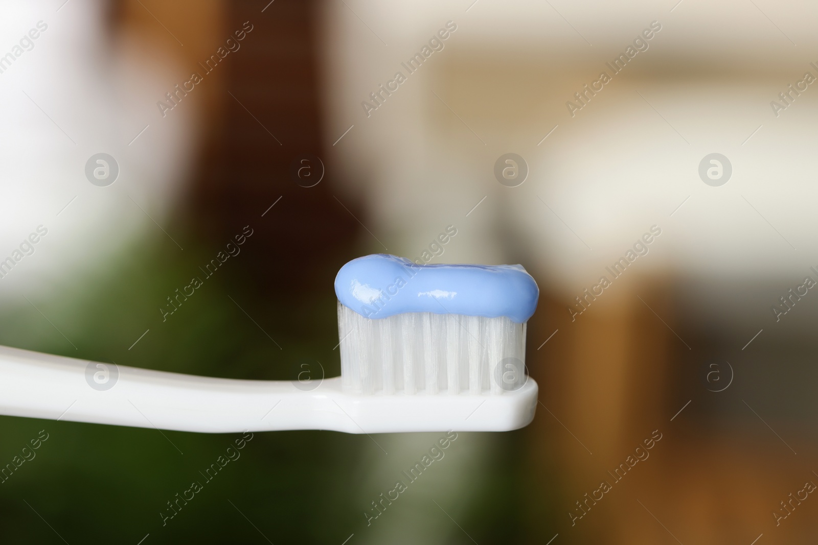 Photo of Plastic toothbrush with paste on blurred background, closeup