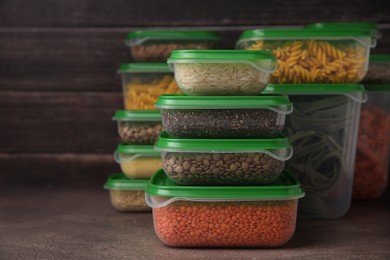 Photo of Plastic containers filled with food products on brown table. Space for text