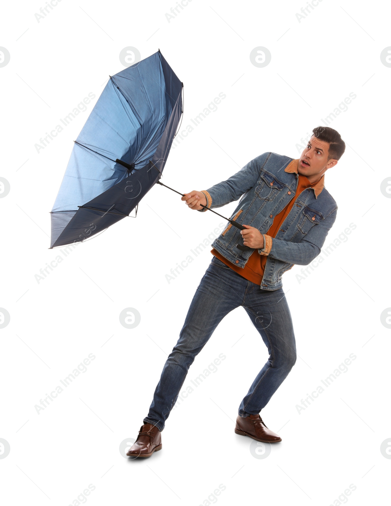 Photo of Emotional man with umbrella caught in gust of wind on white background