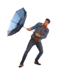 Emotional man with umbrella caught in gust of wind on white background