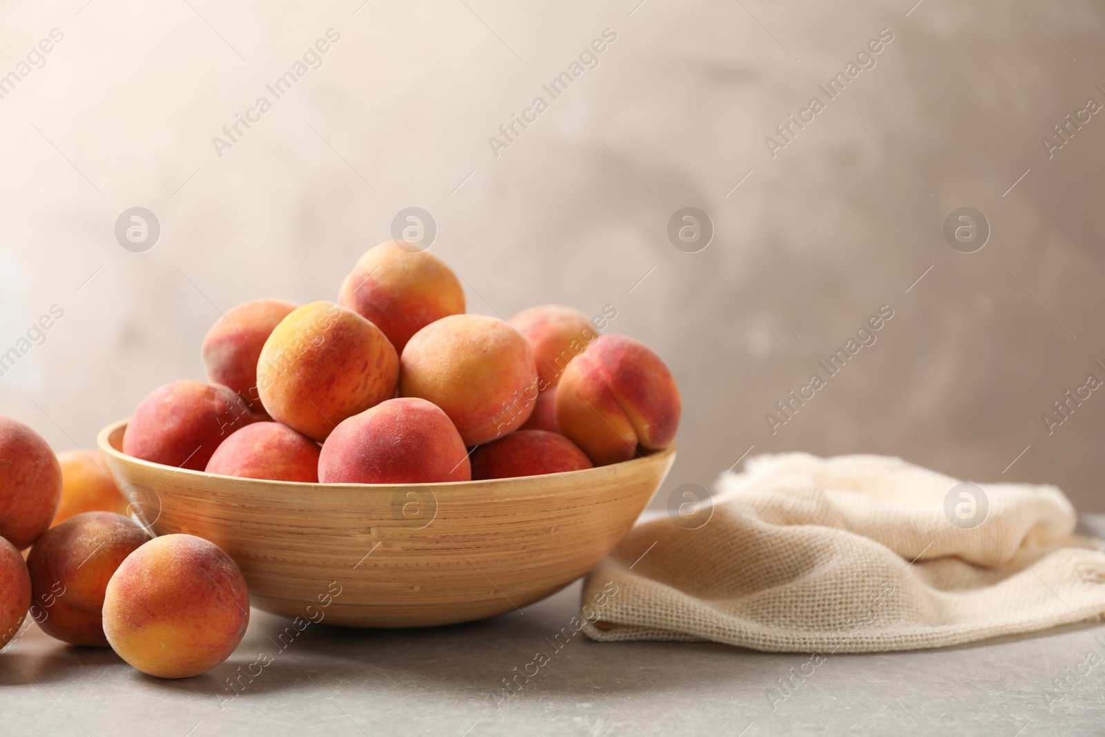 Photo of Delicious ripe peaches on table against grey background