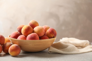 Delicious ripe peaches on table against grey background