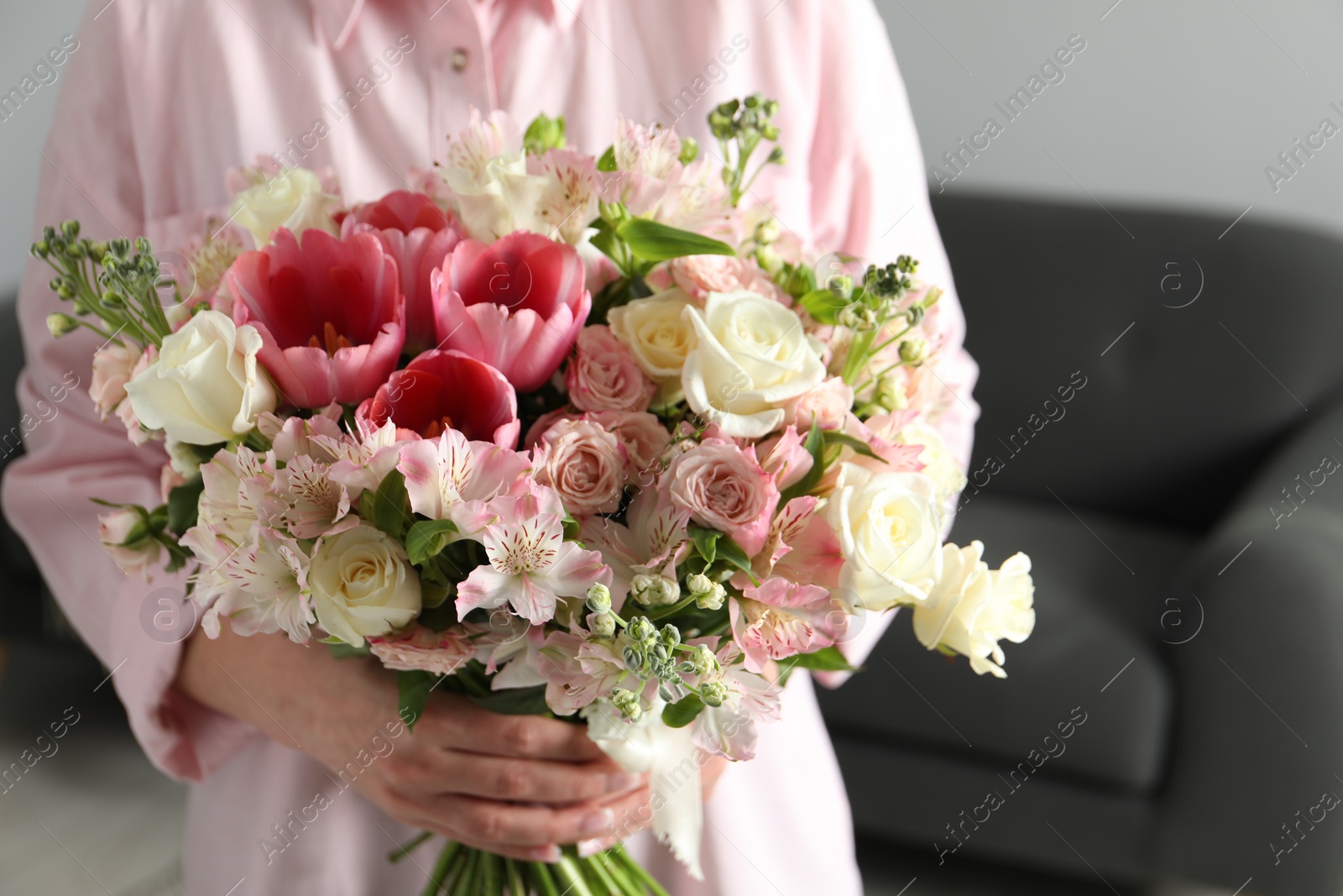 Photo of Woman with beautiful bouquet of fresh flowers indoors, closeup