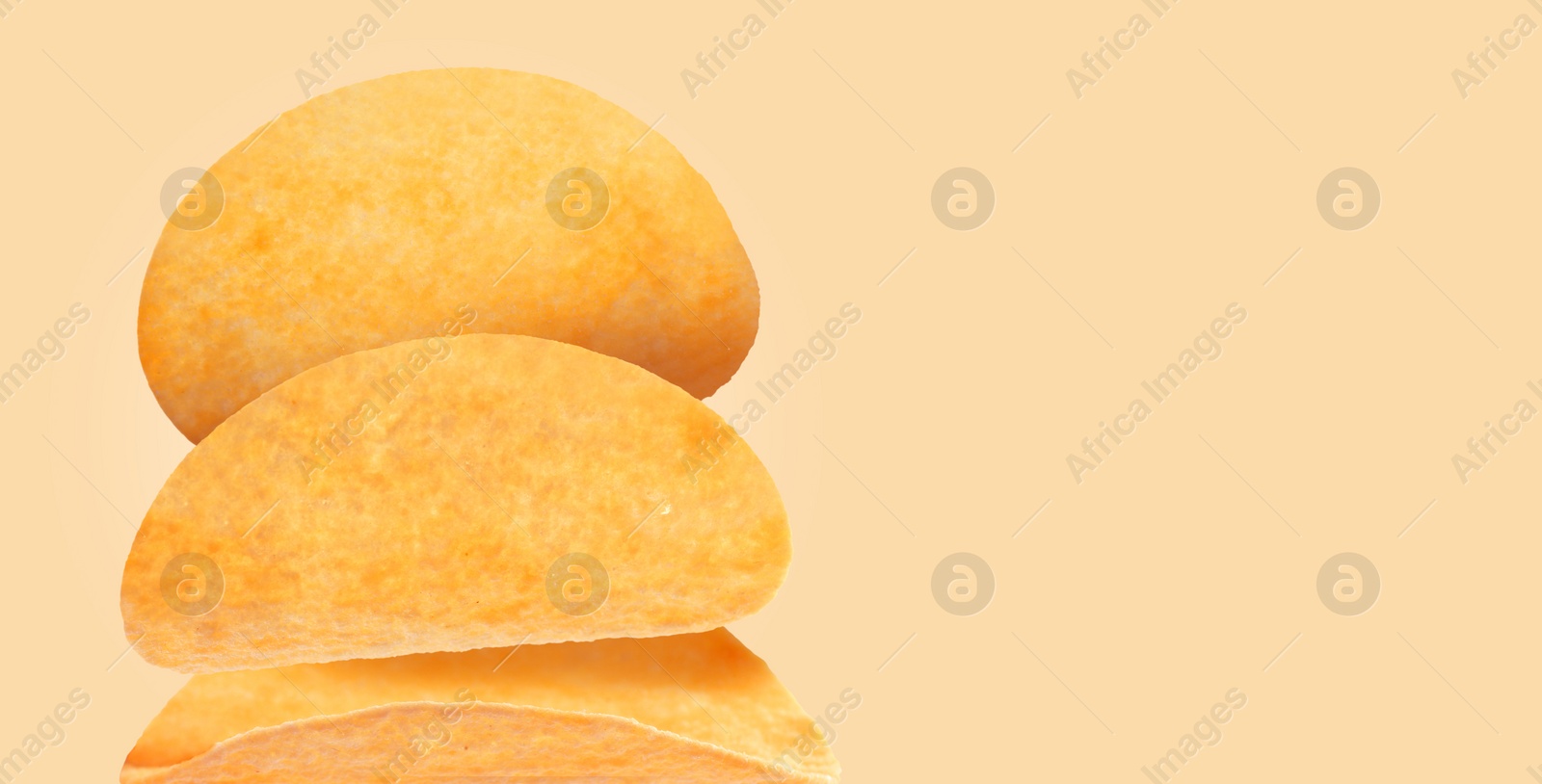 Image of Stack of tasty potato chips on beige background, space for text