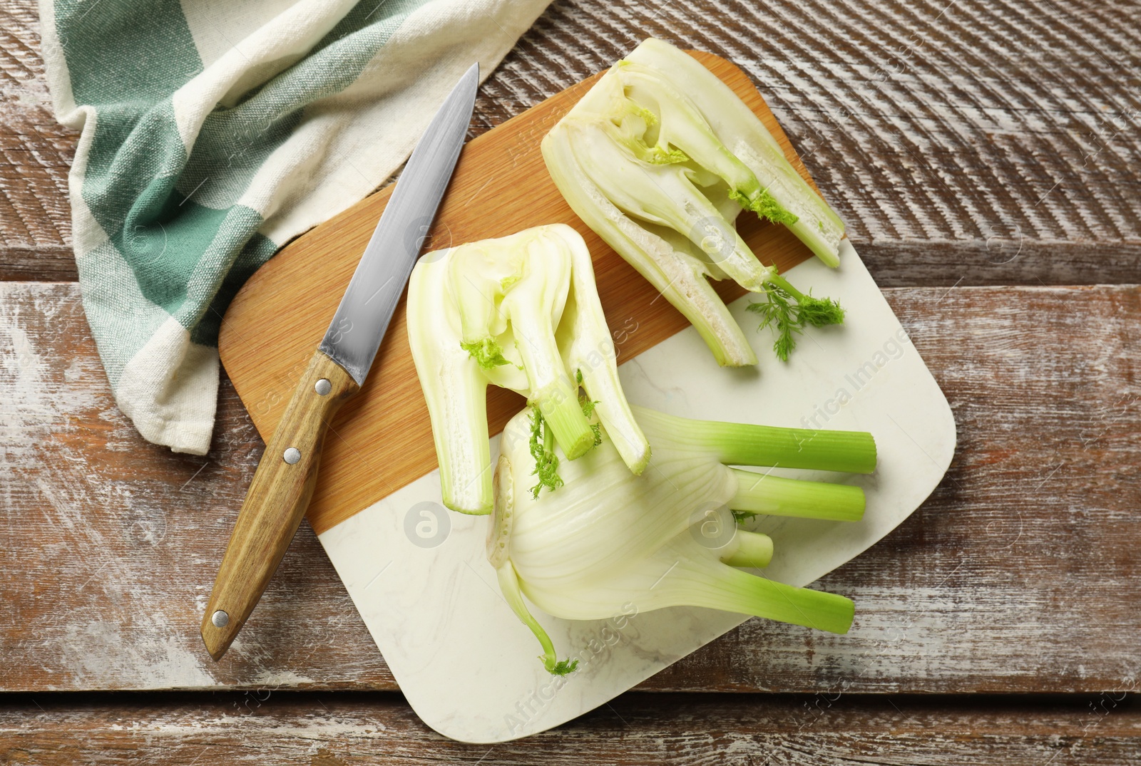 Photo of Fresh raw fennel bulbs and knife on wooden table, top view