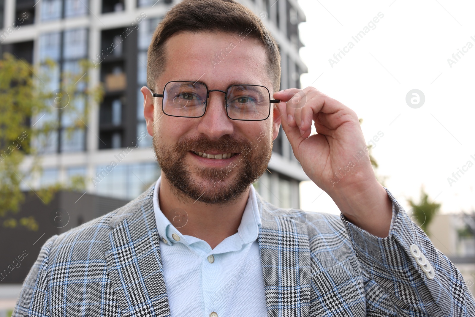 Photo of Portrait of handsome bearded man in glasses outdoors