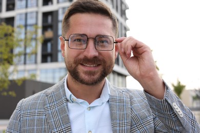 Photo of Portrait of handsome bearded man in glasses outdoors