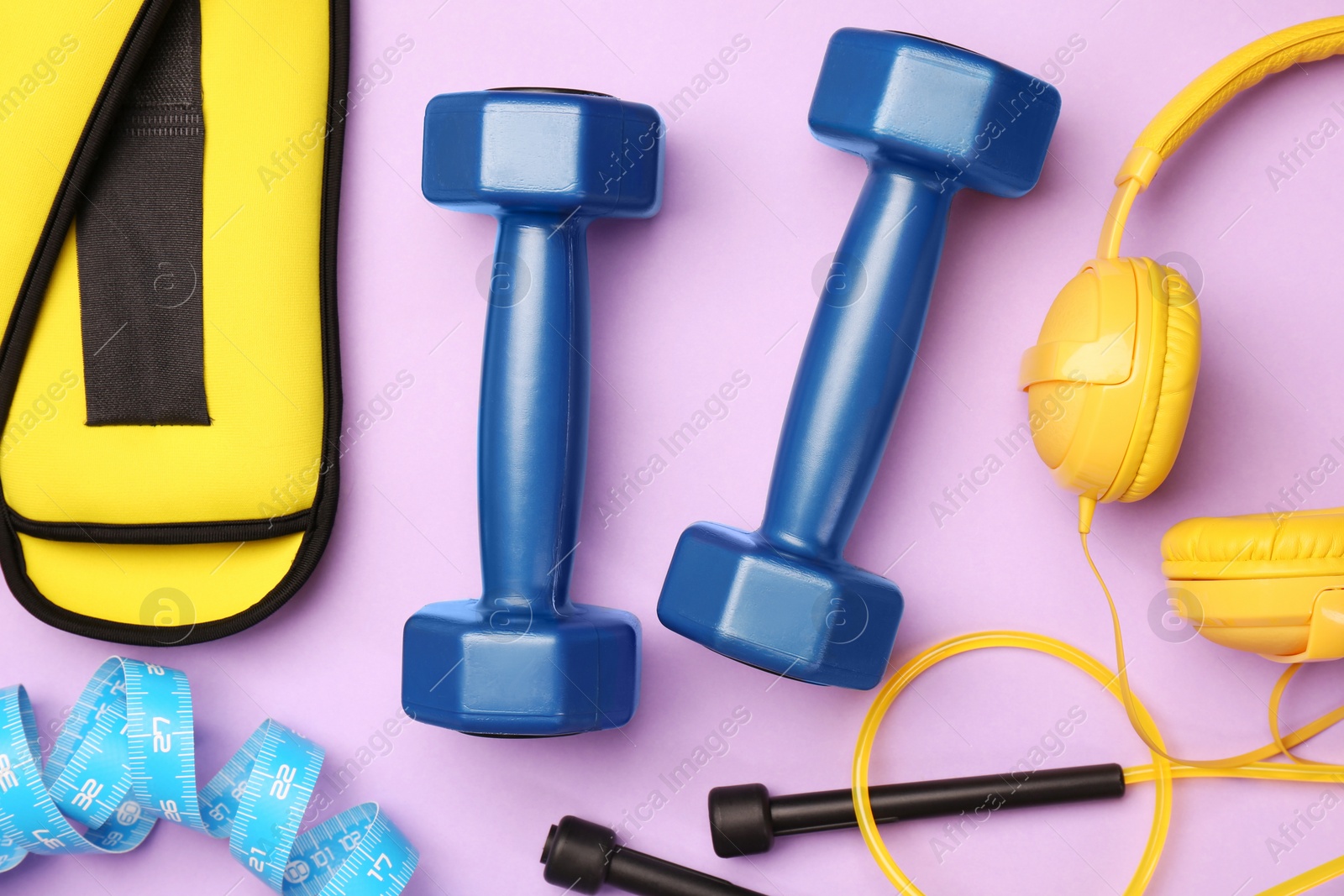 Photo of Flat lay composition with dumbbells on violet background